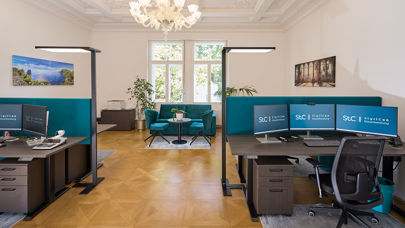 Moderne B&uuml;roumgebung mit Schreibtischen, Monitoren, bequemen Sitzm&ouml;beln und Pflanzen.